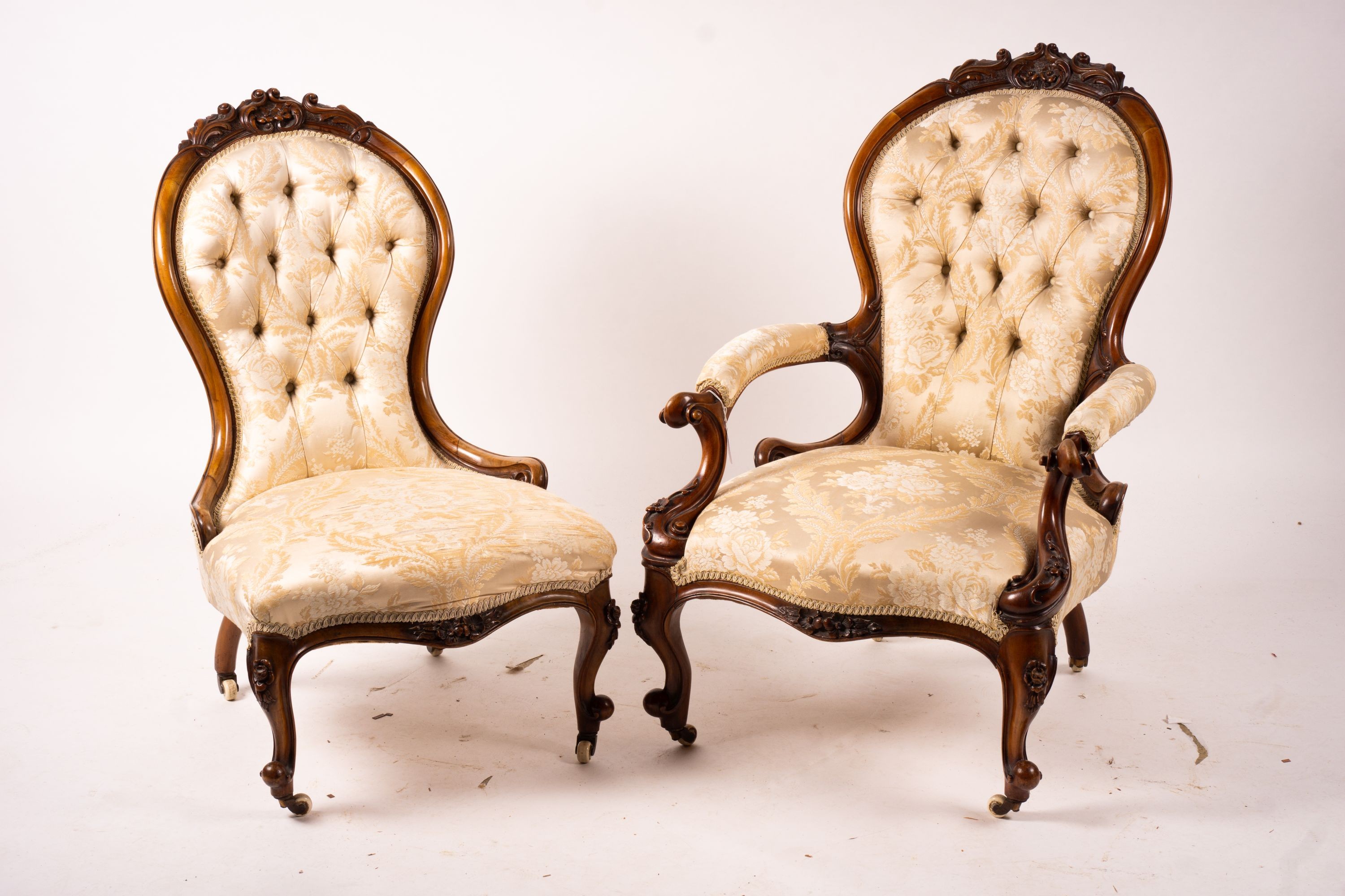 A late Victorian carved walnut three piece salon suite, comprising chaise longue, open armchair and nursing chair